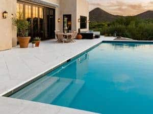 An image of a pool area tiled with Peacock Pavers Rice White pavers.