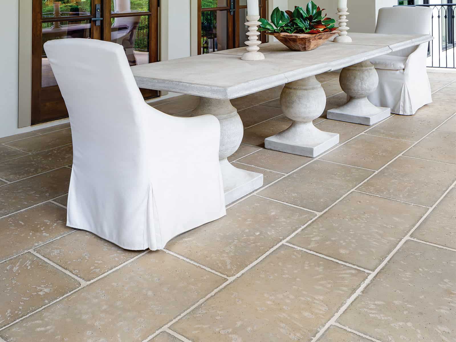 paver patio into an exquisite outdoor dining space with stone table and white chairs