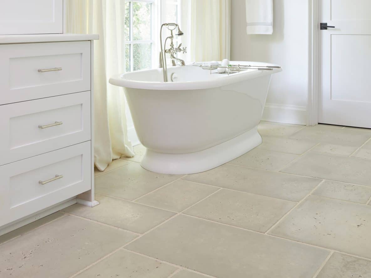 Oyster shell pavers in a white bathroom featuring a free-standing bath.